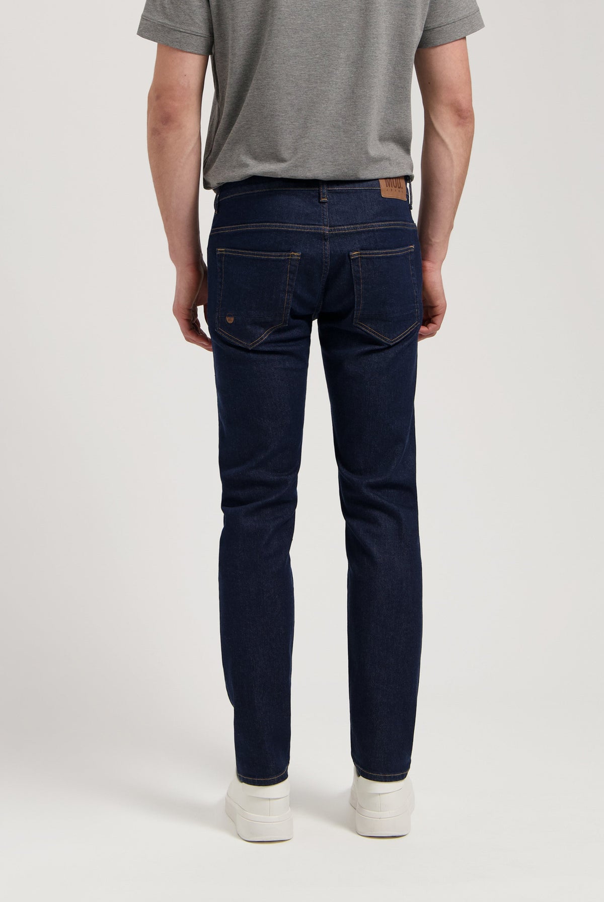Sustainable MUD Jeans in dark denim paired with a cozy gray sweater, showcasing ethical fashion for modern style.