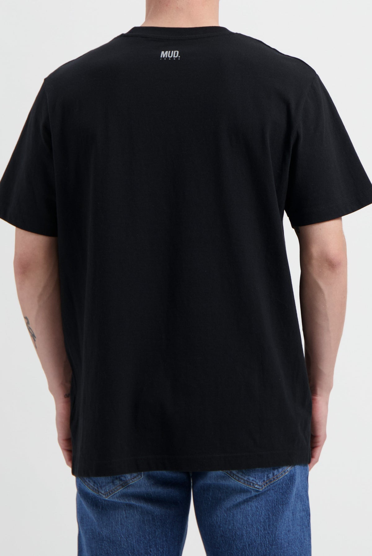 Sustainable MUD Jeans made from organic cotton, featuring stylish gray denim, worn with a black shirt.