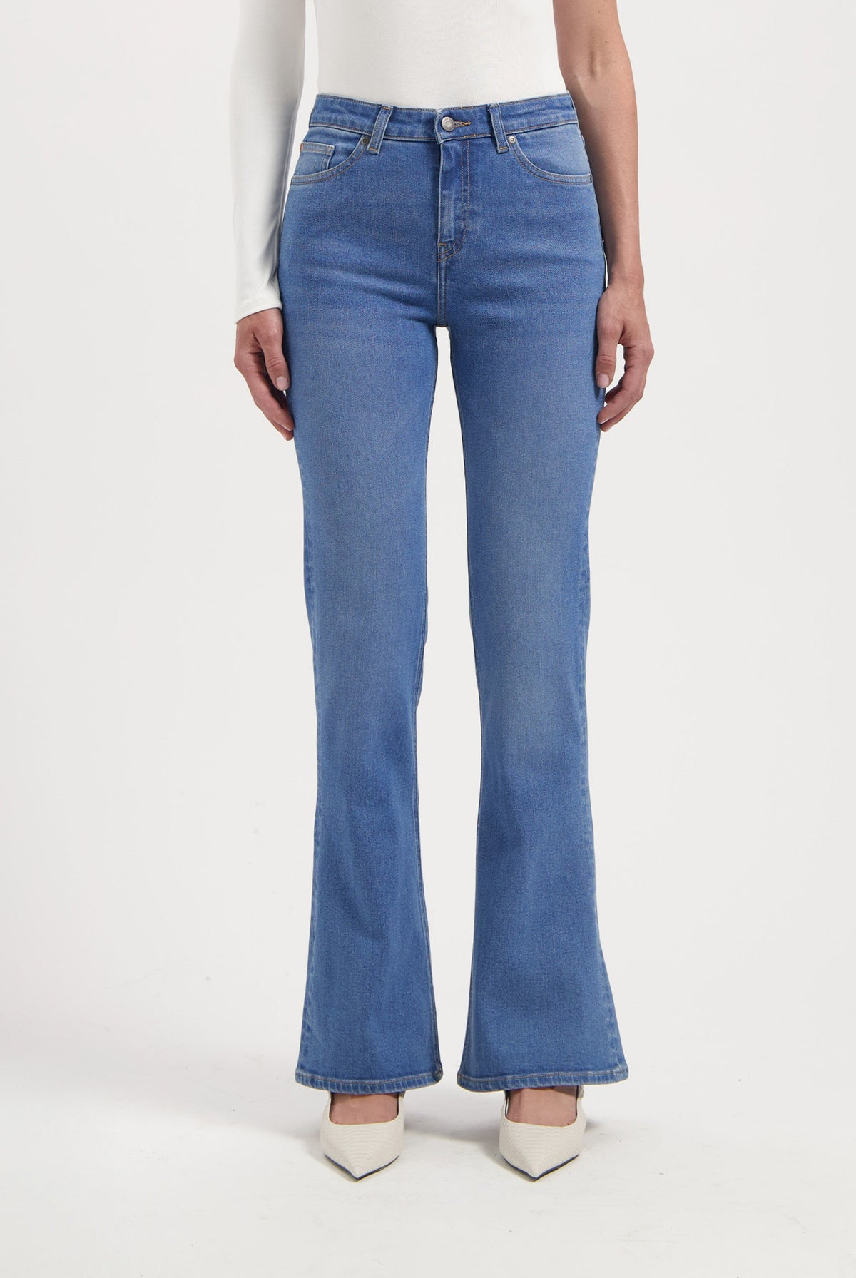 Women's blue high-waisted flared jeans paired with a white long-sleeve top, showcasing a classic, elegant style.