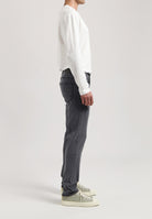 Sustainable MUD Jeans in dark denim, crafted from ethical materials, paired with a light gray sweater.