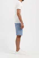 Sustainable MUD Jeans in deep blue denim, crafted from organic cotton, paired with a light gray sweater for an eco-friendly look.