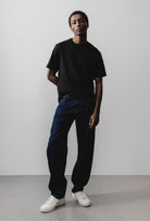 Sustainable MUD Jeans made of organic cotton in sleek black denim, paired with a gray sweater for an ethical style.