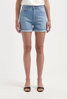 A pair of light blue denim shorts with rolled cuffs, worn with a simple white top, showcasing casual summer style.